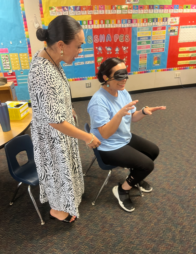Staff blindfolded sitting in a training for deaf blind 
