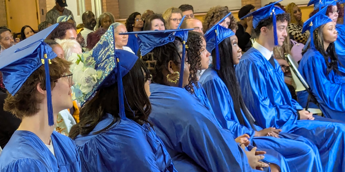 graduates sitting in caps and gowns