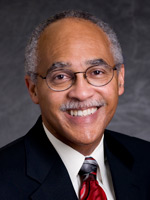 A headshot photo of a man wearing a suit and tie