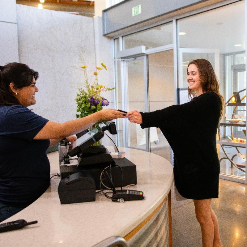 Student handing meal card to cashier to swipe in to Segundo DC