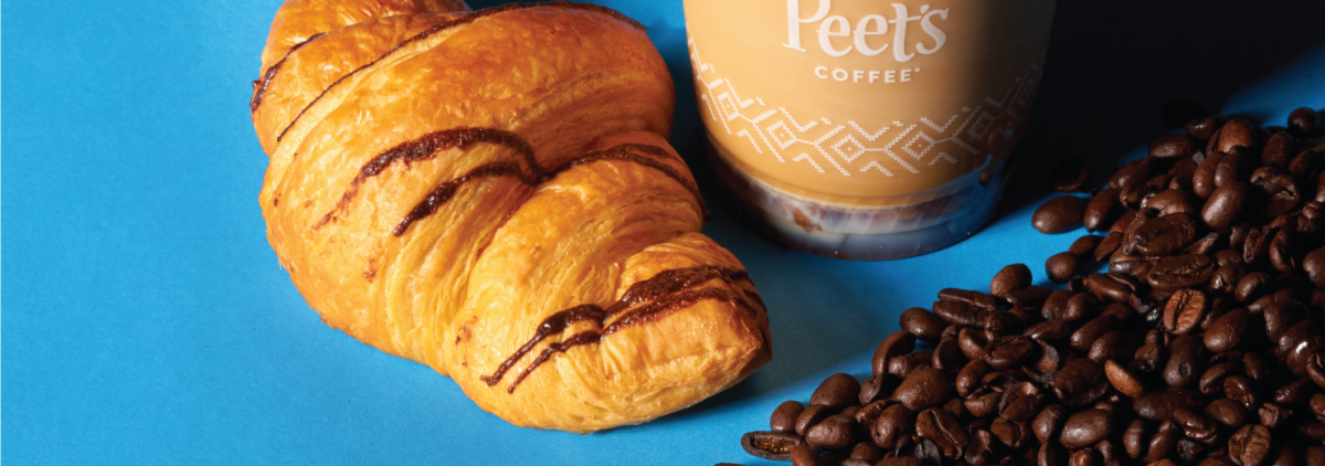 A croissant and some coffee beans