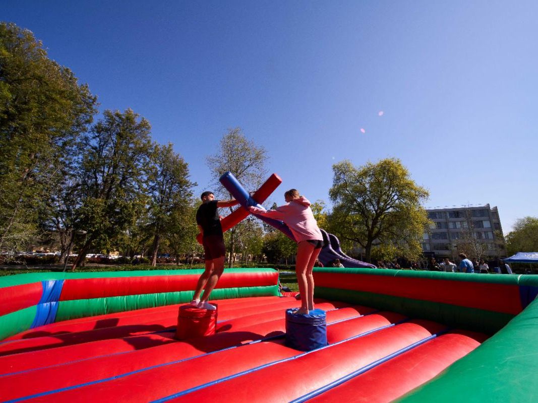 Two people dueling with inflatable swords