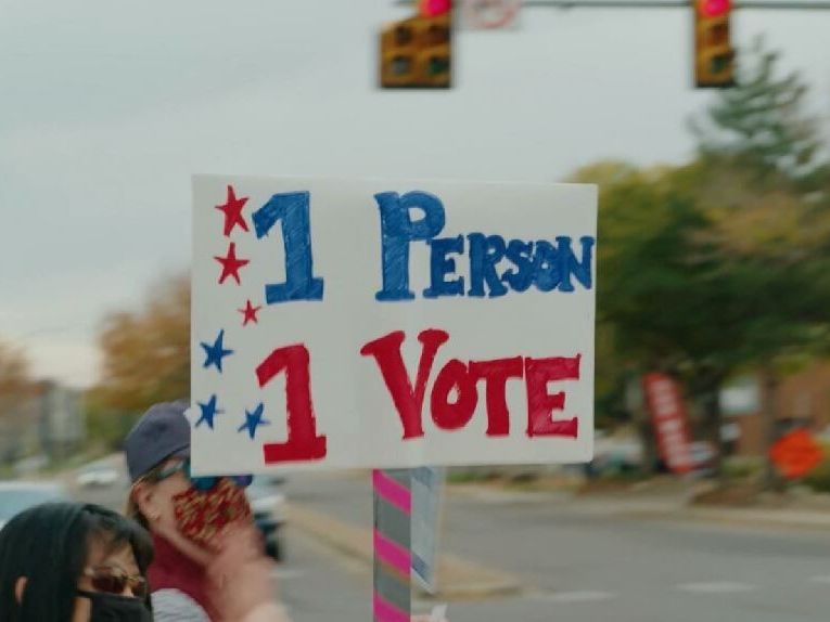 An image of the electoral college with hands raised around it