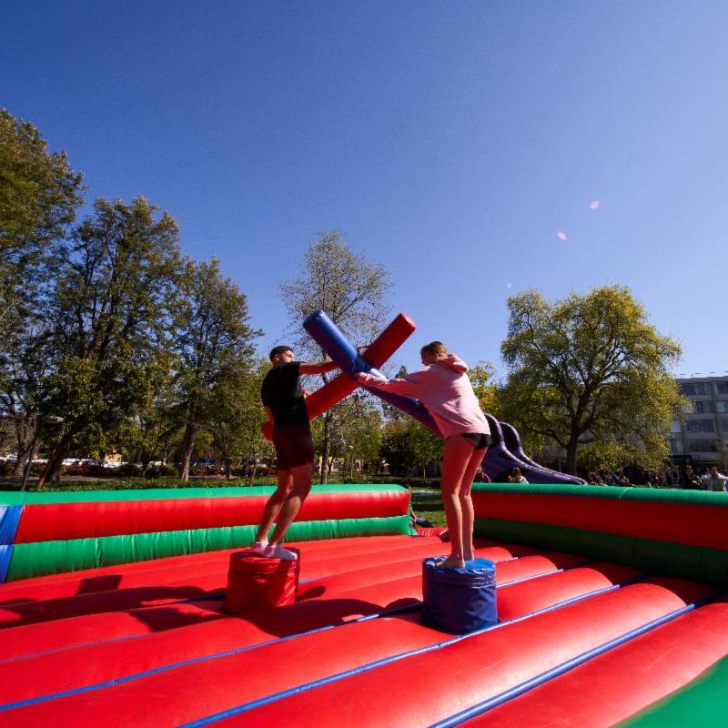 Two people dueling with inflatable swords