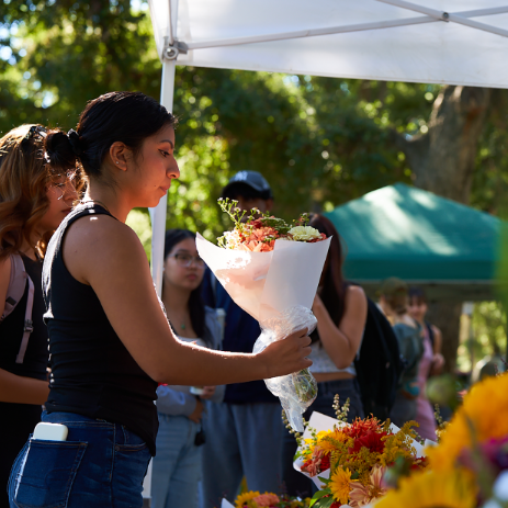 A woman buying flowers from a woman selling flowers