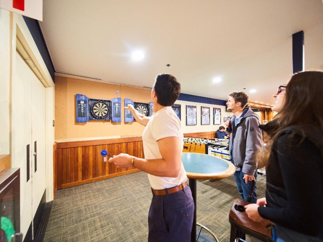A student throwing a dart at a dartboard