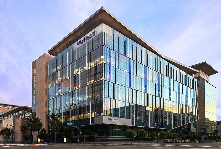 Exterior of the UCSF Health medical building with a modern glass facade under a blue sky.