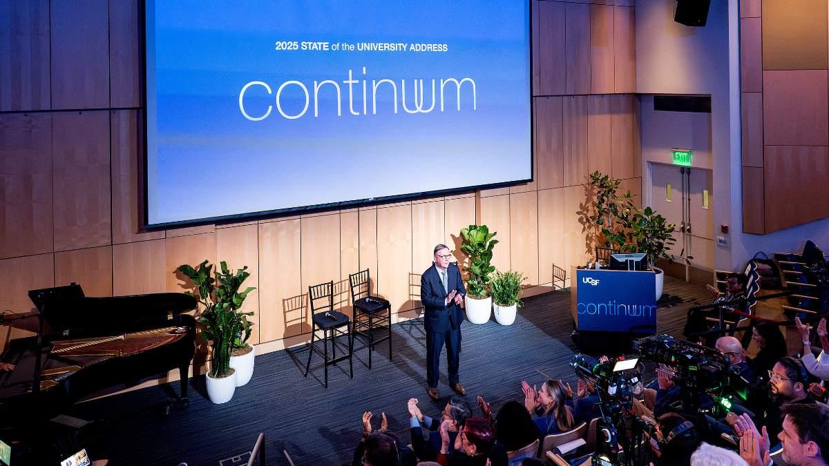 Chancellor Sam Hawgood presenting in an auditorium in front of a large screen