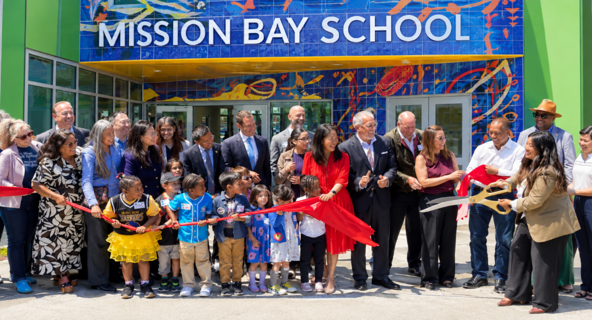 Students, families, and community leaders gather for a ribbon-cutting ceremony outside Mission Bay School.