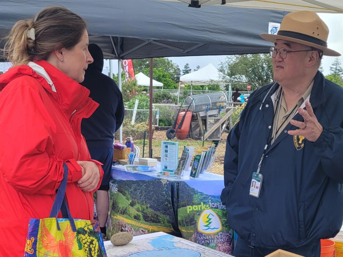 CDFA representative talking with a woman at a public information booth
