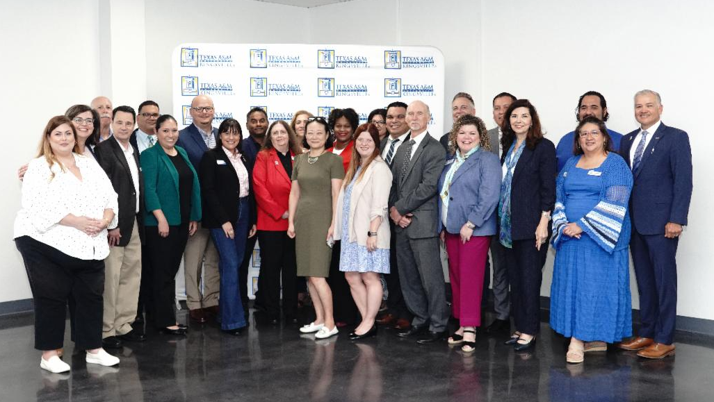 A group of community college and university leadership smile at the camera.