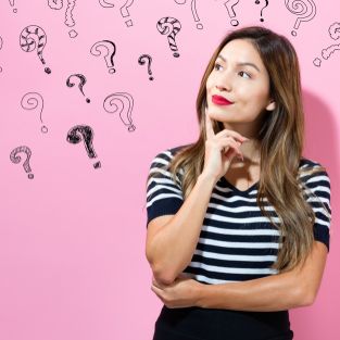 Stone with a painted smile. On the shore_ one stone stands out from the others. On a small stone is an image of a happy face. Concept  joy_ happiness_ positive_ kindness.