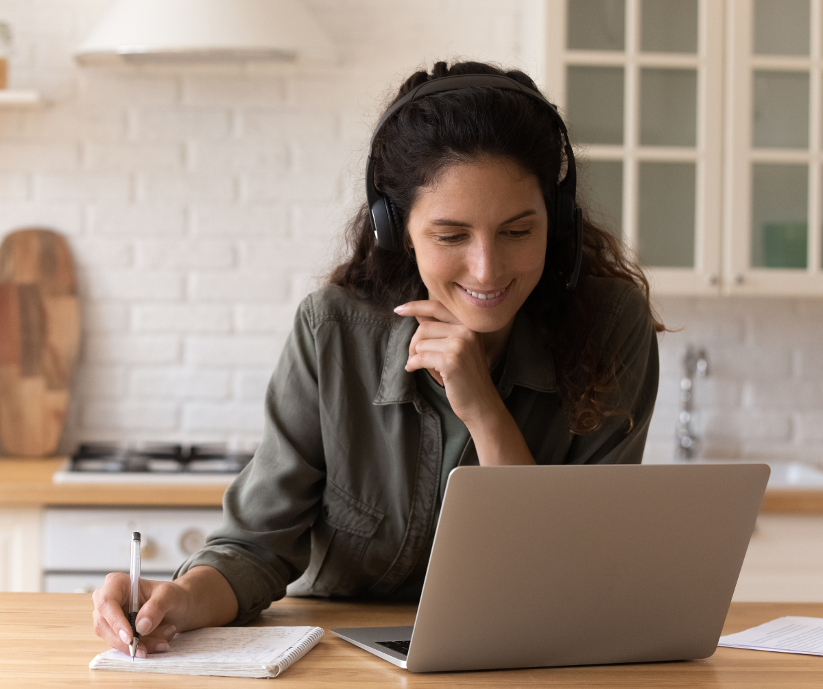 A person participates in a webinar in her kitchen.