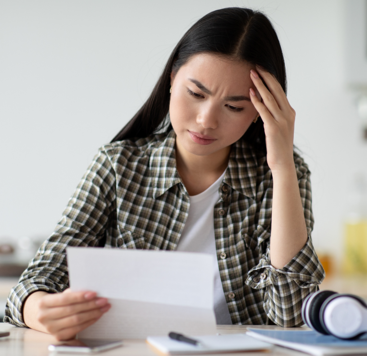 A person reading a letter has a concerned look on her face.