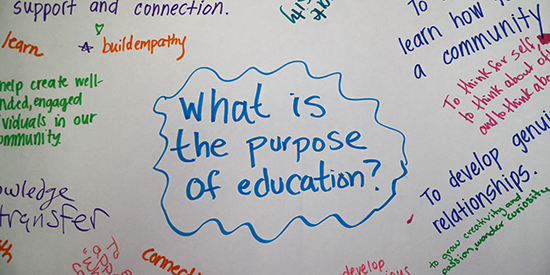 Colorful marker writing on a white piece of paper answering the prompt what is the purpose of education