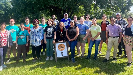 20 adults smile for a group photo behind a sign that reads CT Farm to School Institute