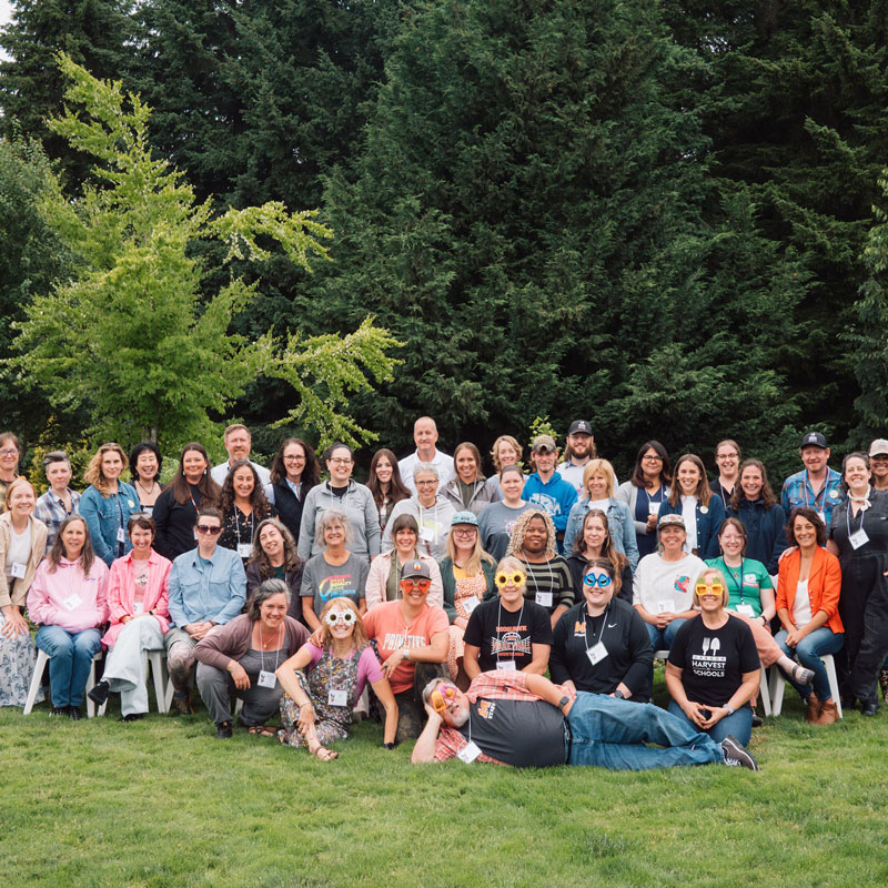 A large group of farm to school practitioners gather for an outdoor group photo