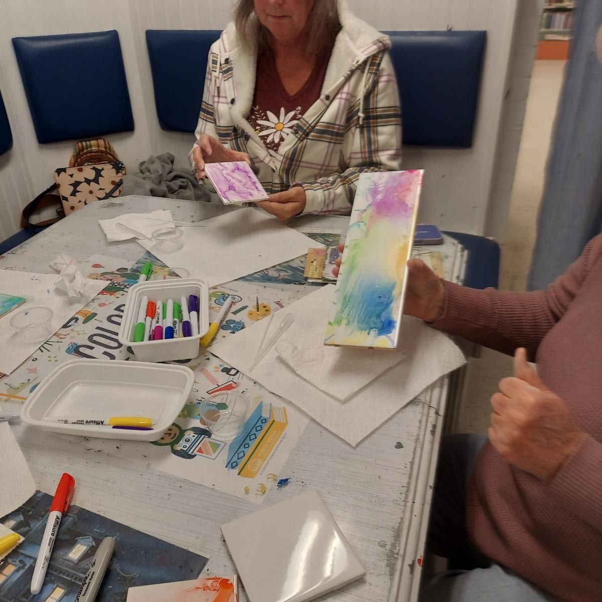 Patrons displaying tiles in progress from Workshop Wednesday