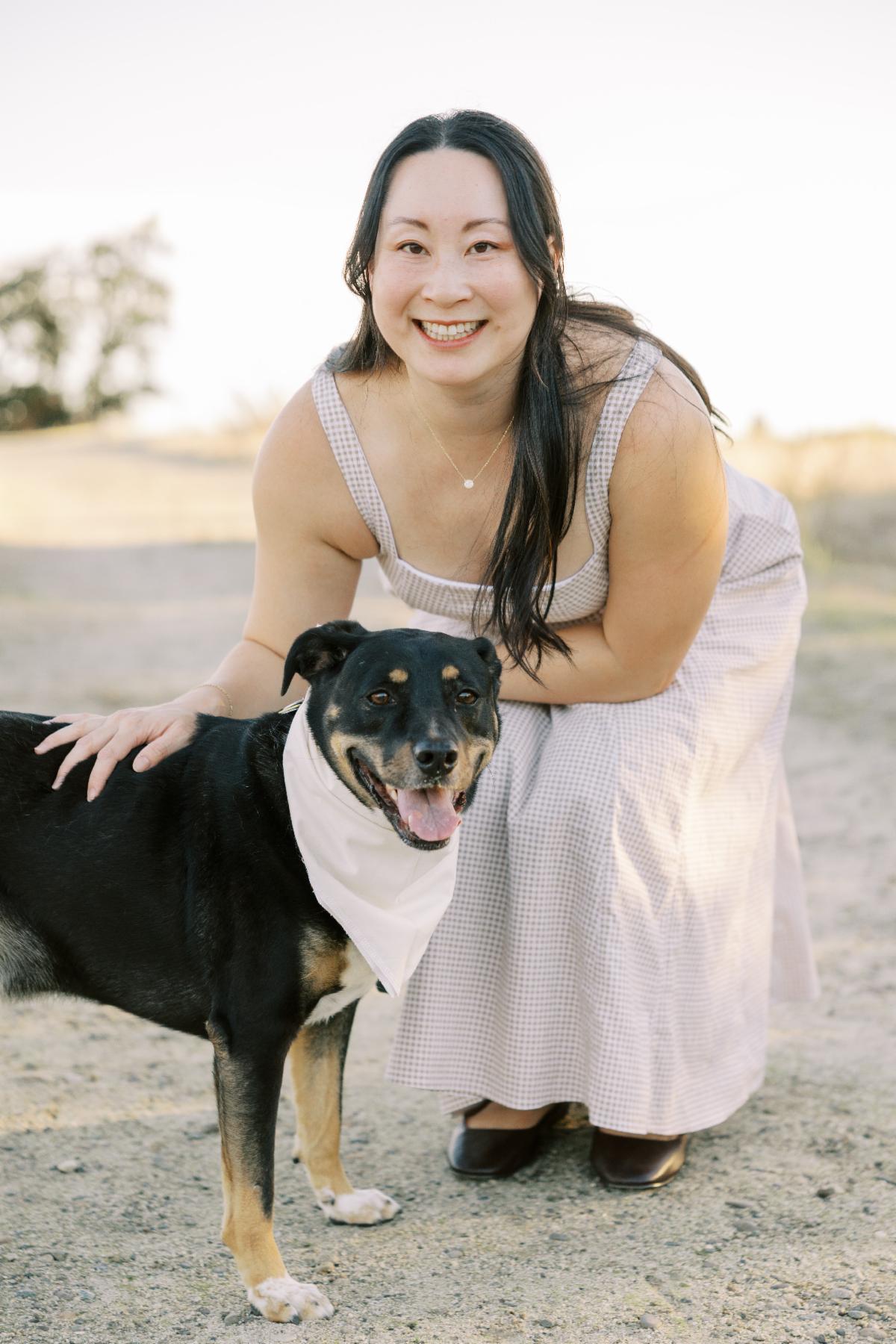 Vi posing outdoors with her dog named Buster.