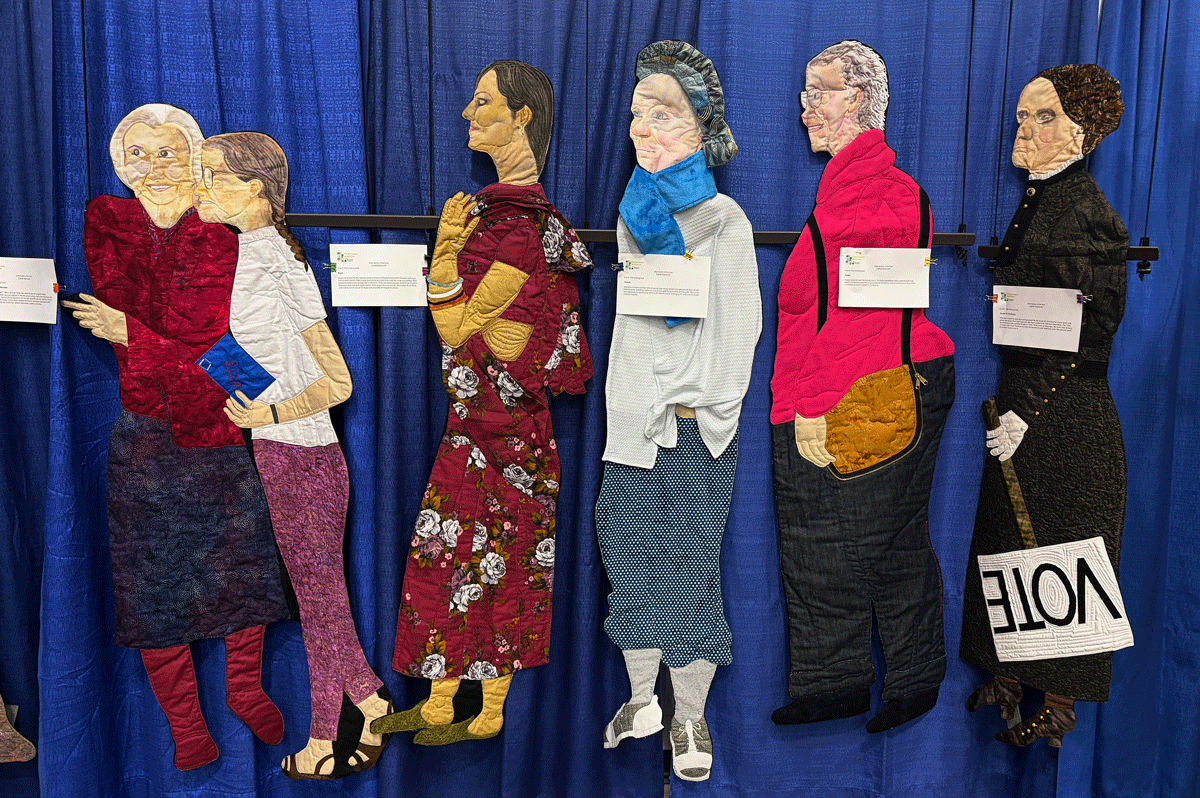 Quilted images of people standing in line to vote