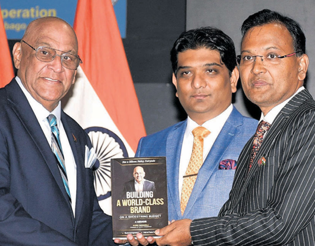 Minister of Trade, Investment and Tourism Satyakama Maharaj, left, presents a copy of his book to Indian High Commissioner Dr Pradeep Rajpurohit at the launch of the T&T Indian Business Federation at the Mahatma Gandhi Institute for Cultural Cooperation in Mt Hope on Sunday. Looking on is TTIBF president Vaalmikki Arjoon . PHOTO BY SHASTRI BOODAN