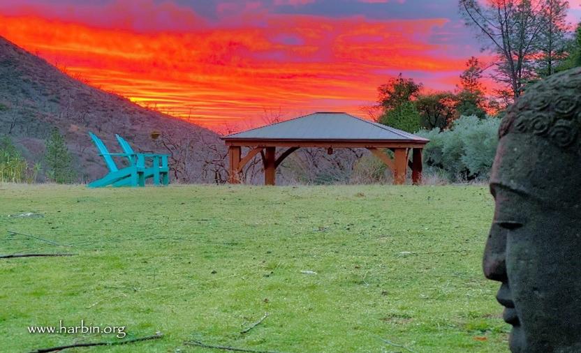 Photo of cloudy red sunrise sky with statue in foreground.