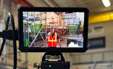 The previous screen on a camera shows an IHSA Health and Safety Consultant delivering a safety talk 