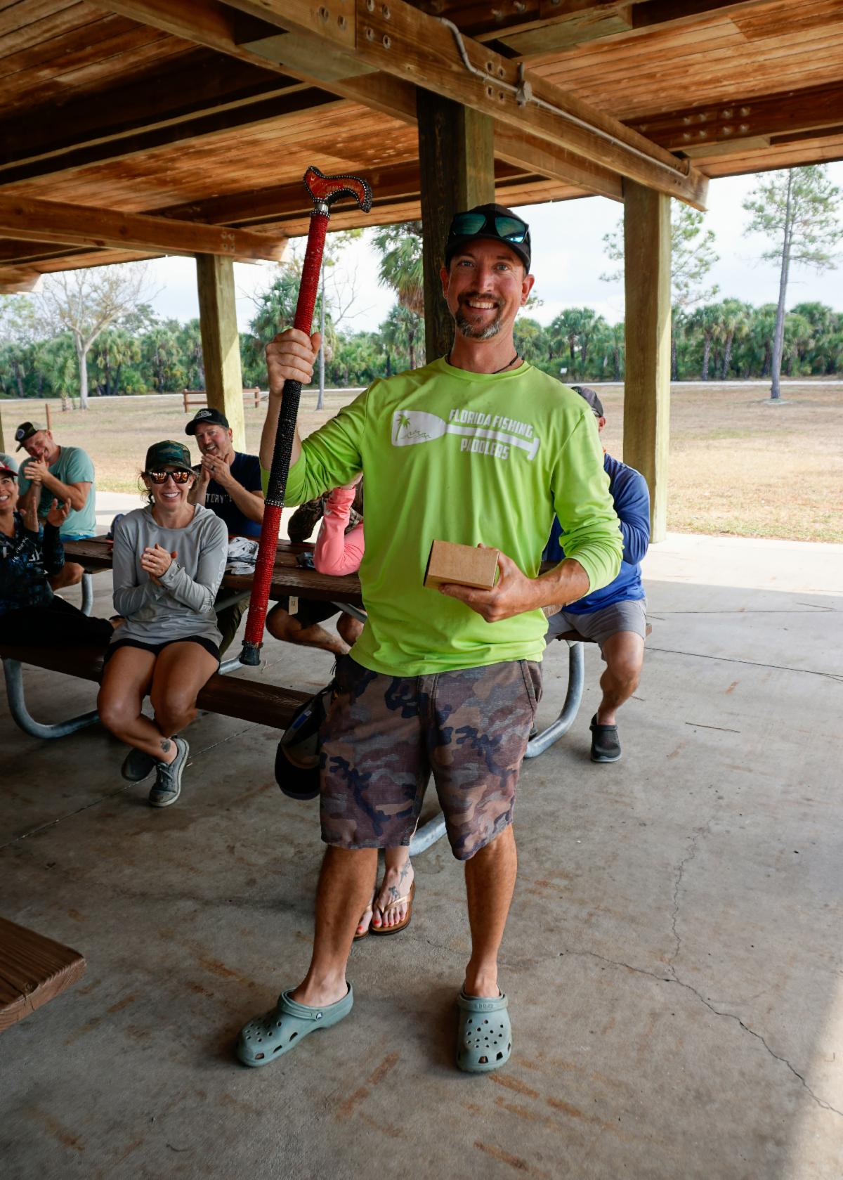 The winner of the strangest item hold his prize and the bejeweled cane