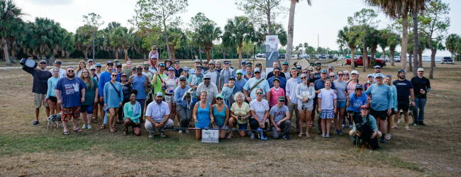 2025 Debris Derby participants. A large group of people smile for the picture.