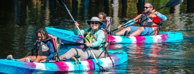 Two people each on two colorful kayaks