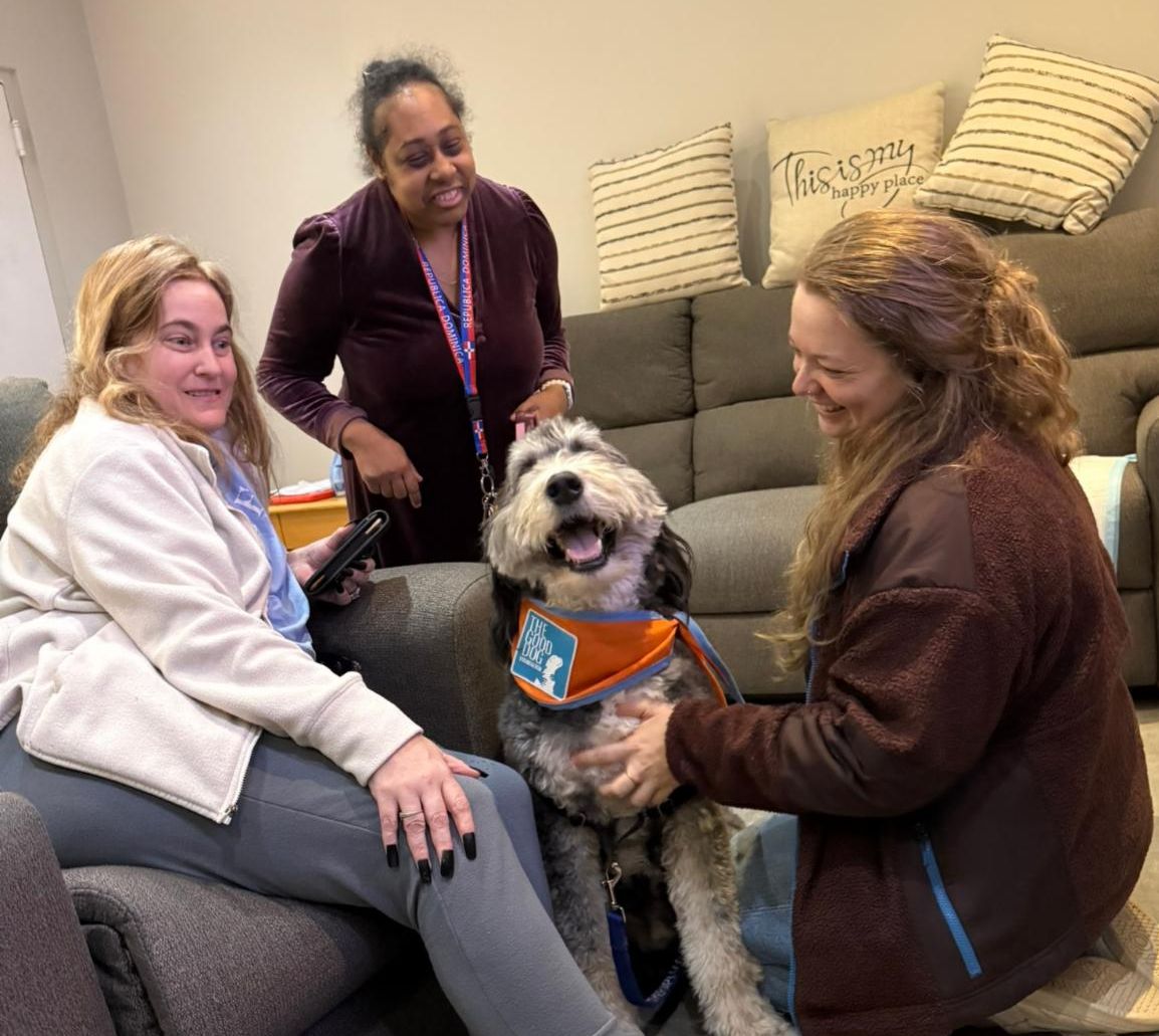 Beto the dog sits in the middle between two JP residents and Ashley  his owner. 