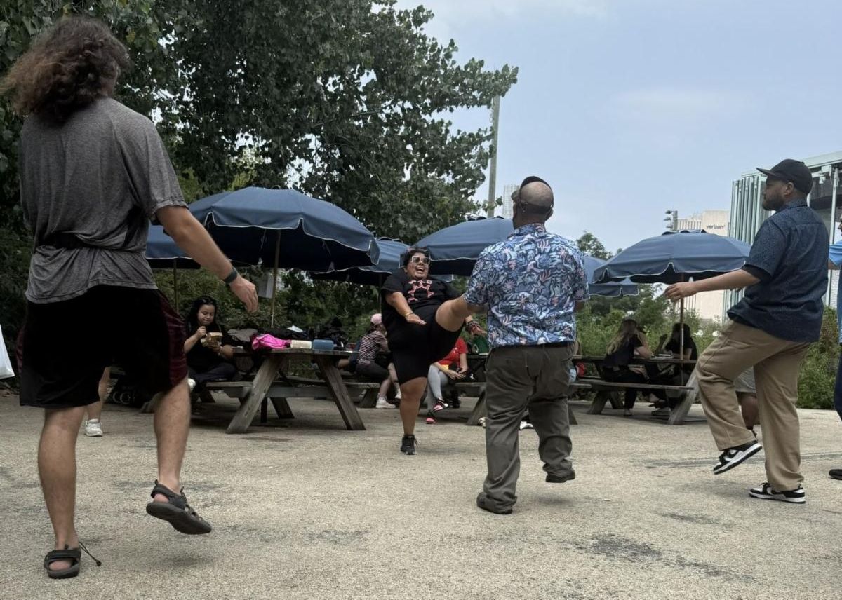 A group of people dance in a park. 