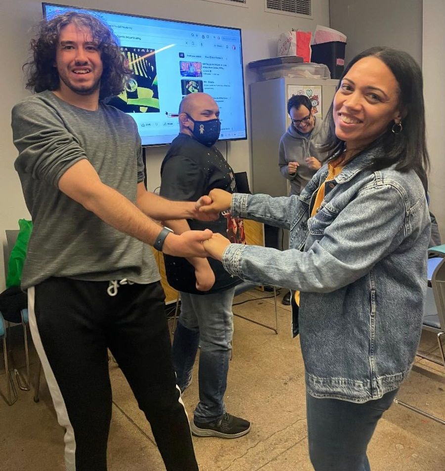 Maria is dancing with Casey. She is wearing a denim jacket and he has a mop of curly hair. 