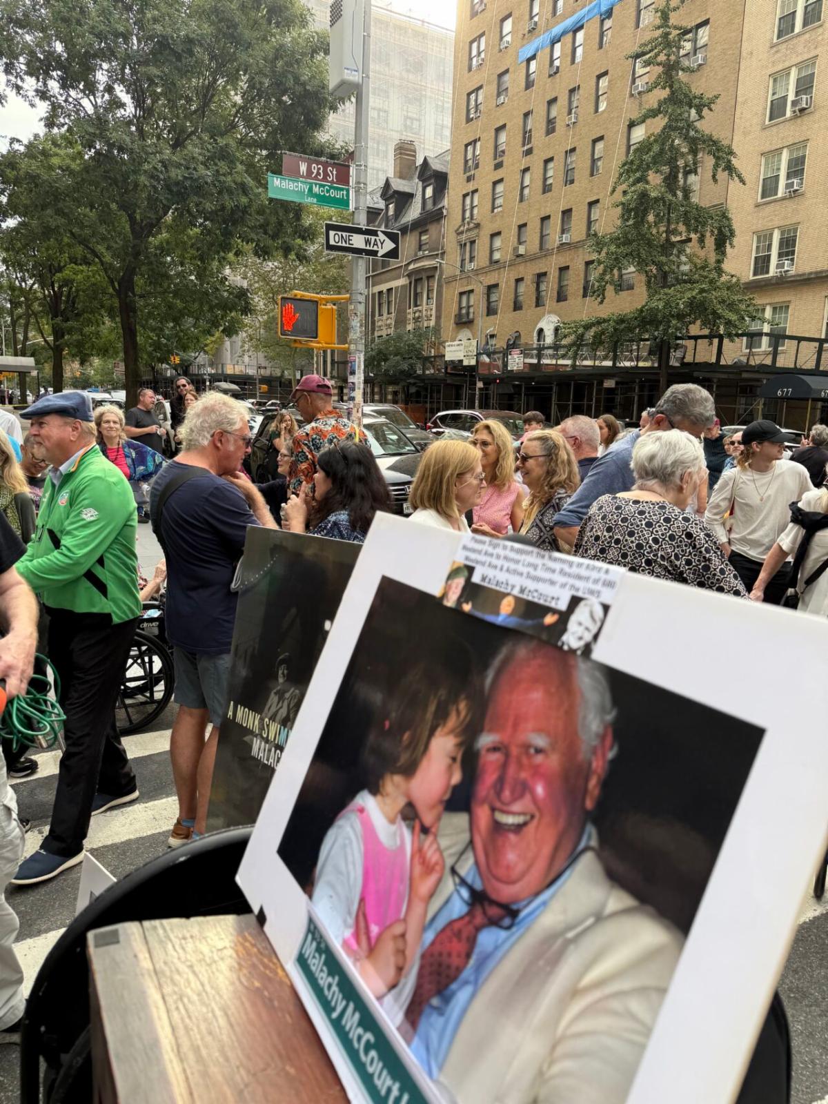 A photo of Malachy is propped up on a podium and the street sign that bears his name can be seen in the background. 
