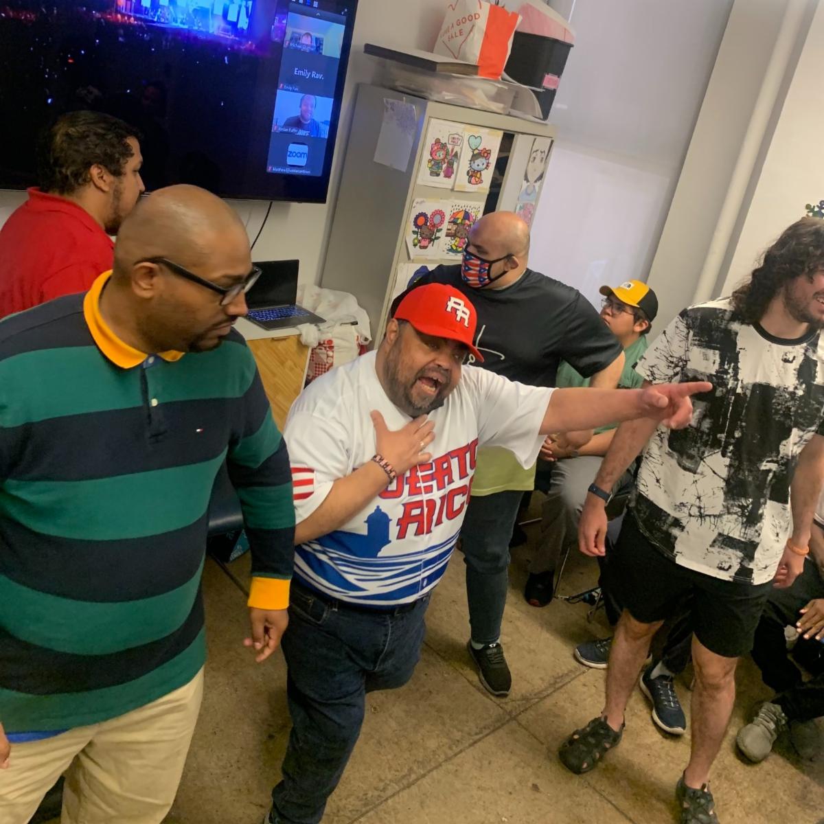 Juan is dancing with other people in Job Path's conference room. 