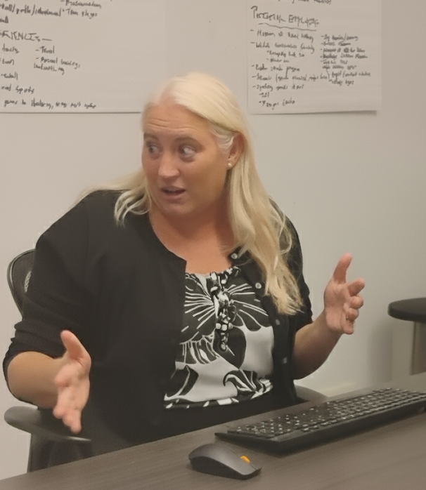 Michael Anne gestures in a conference room. 