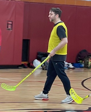 Kevin is in a gym with a hockey-like stick 
