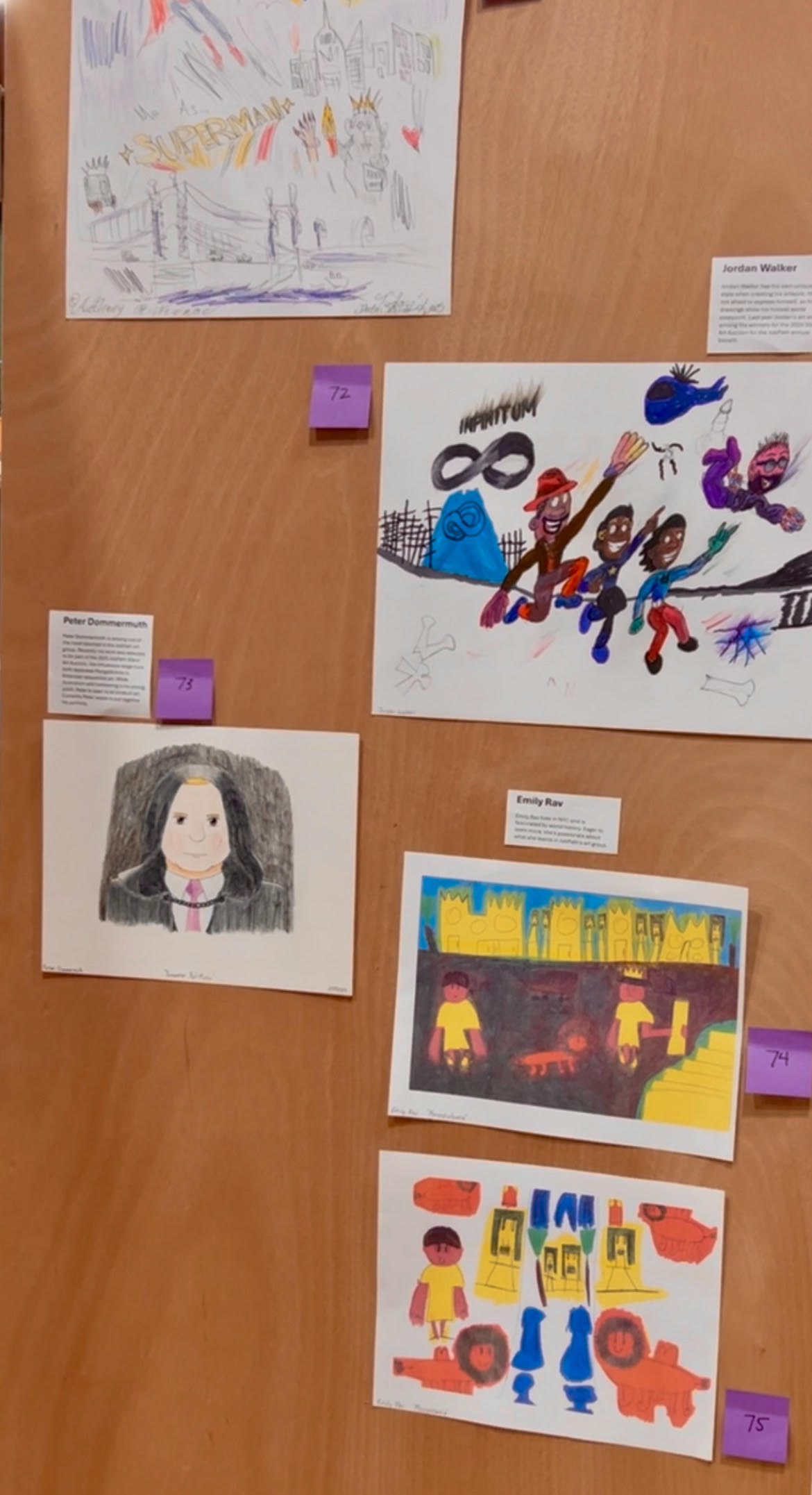 Several works of colorful art are affixed to a wall. 