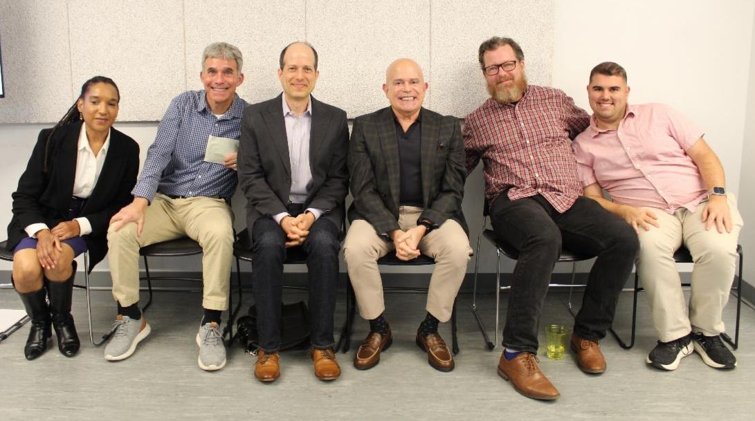 A row of people sitting in a line. 