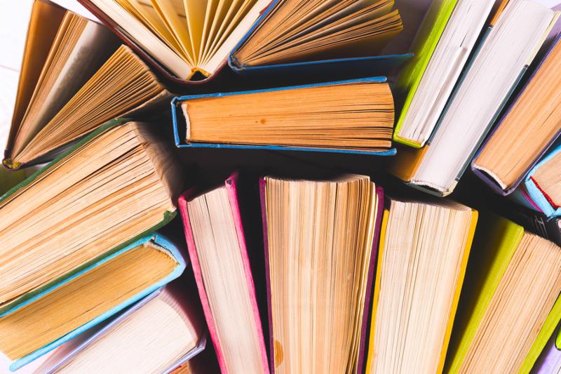 Open book_ hardback books on bright colorful background. Back to school. Copy space for text. Set of books in the library. Knowledge_ Science.