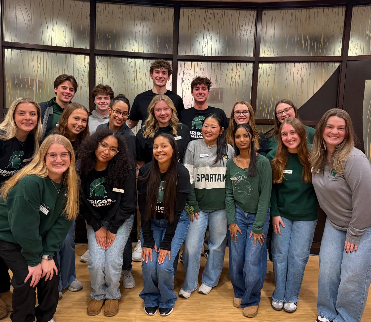 17 Briggs Ambassadors in MSU attire pose for a picture on a visit day