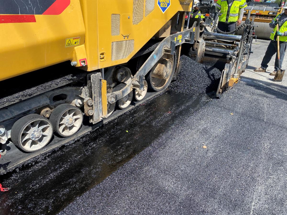 Crews placing the top layer of asphalt on 9000 South. This top layer provides a smooth ride and removes water from the road to improve traction. 