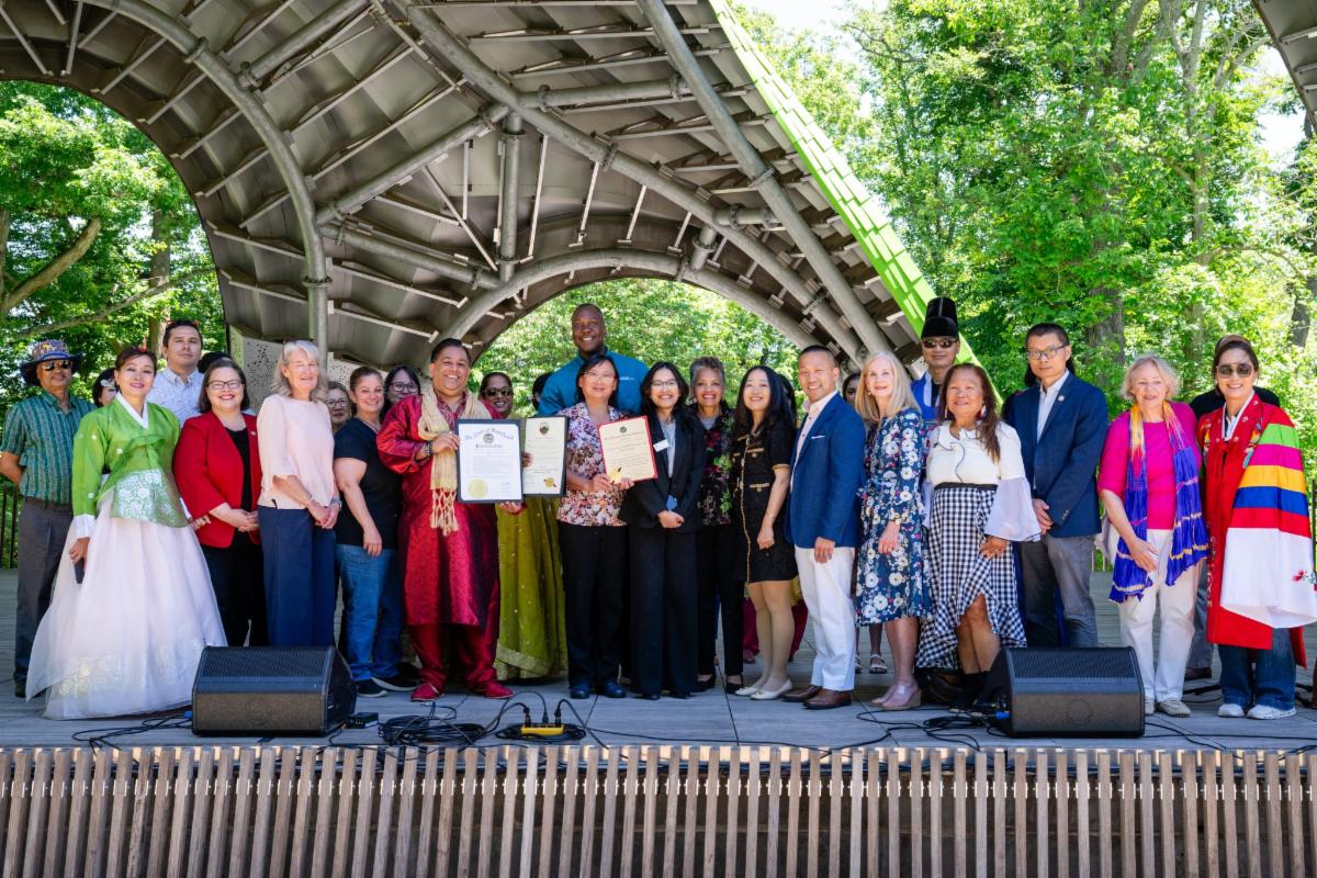 County Executive Calvin Ball on stage at The Chrysalis at Merriweather Park with participants of Howard Countyâs annual Asian American and Pacific Islander Festival.