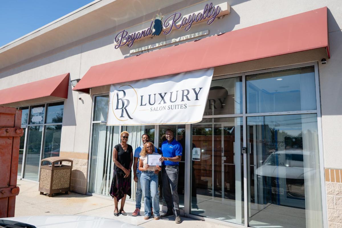 County Executive Calvin Ball posed outside of BR Luxury Salon Suites' Beyond Royalty Beauty Bar & Suites storefront with owner Brittney Middleton and his significant other and Howard County Economic Development Authority CEO Jennifer Jones.