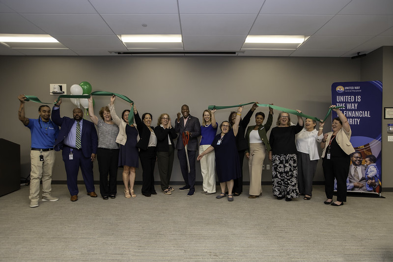 County Executive Calvin Ball posed for a photo with Office of Consumer Protection staff members and other celebrating the cutting of the green ribbon opening the County's first Financial Empowerment Center.