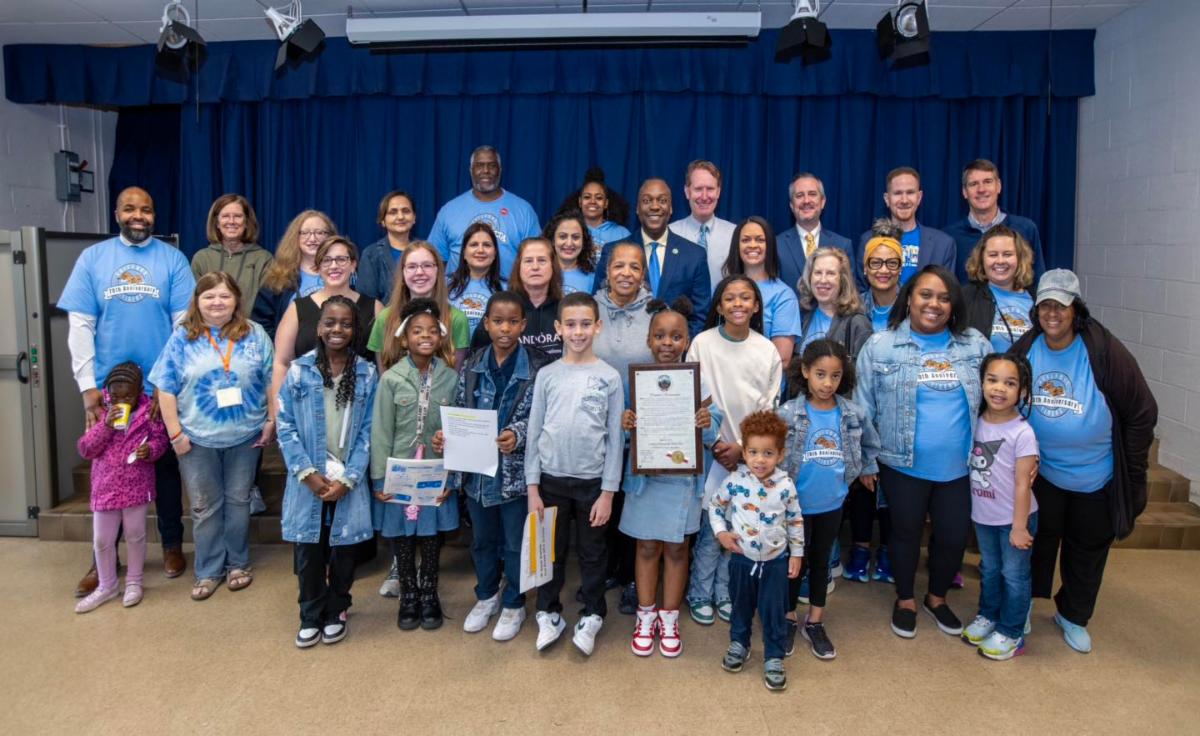 A photo of County Executive Calvin Ball with students, staff, and community members at Guilford Elementary School's 70th birthday celebration.