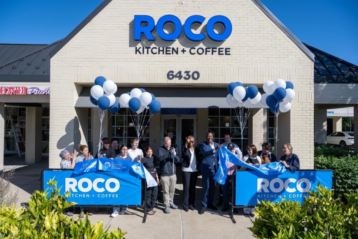 County Executive Calvin Ball with staff members and local outside of ROCO Kitchen + Coffee in Columbia's Hickory Ridge Village Center celebrating the grand opening ribbon just being cut officially opening the new breakfast coffee and lunch spot.
