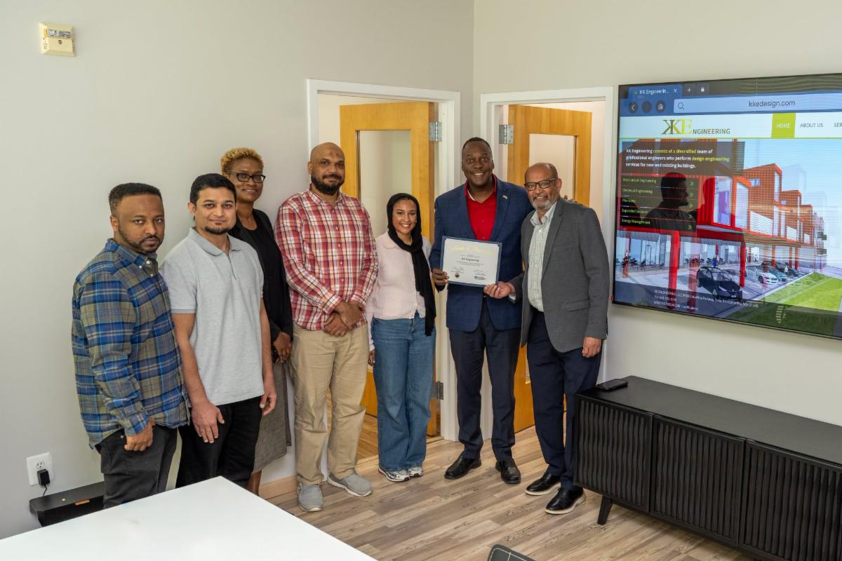A photo of Calvin Ball posing with the staff of KK Engineering