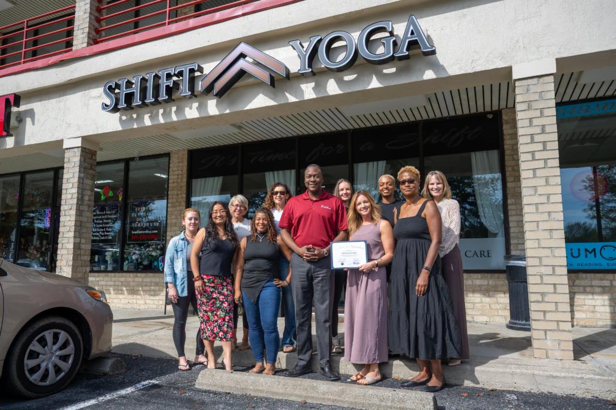 County Executive Calvin Ball posed with SHIFT Yoga & Strength owner Jessie Kates and the entire staff with Howard County Economic Development Authority CEO Jennifer Jones outside of SHIFT Yoga studio.