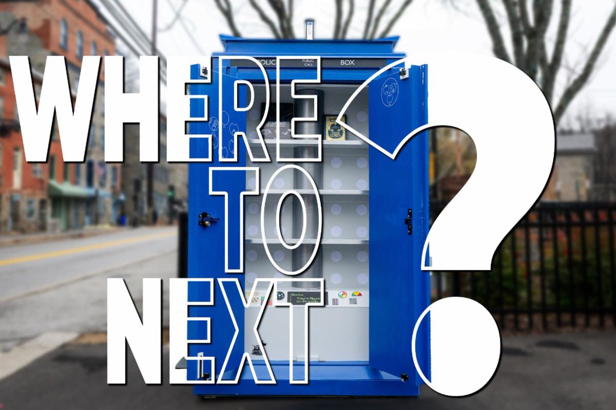 Graphic with an image of the County's little free library TARDIS that appears to be floating again a blurred background picture of downtown historic Ellicott City with text overlay that reads Where to Next?